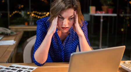 1000 x 667 Stressed businesswoman sitting at her desk in the office 1